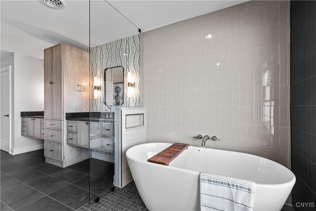 bathroom with tile patterned floors, vanity, tile walls, and independent shower and bath