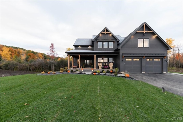 view of front of home featuring a garage, covered porch, and a front lawn