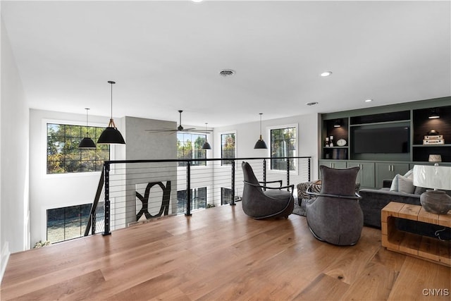 living room with hardwood / wood-style floors, ceiling fan, and a healthy amount of sunlight