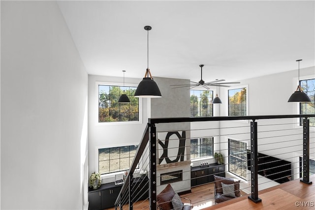 staircase with wood-type flooring and ceiling fan