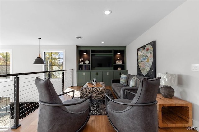 living room with plenty of natural light and light hardwood / wood-style flooring