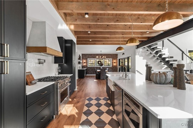 kitchen with dark hardwood / wood-style floors, beamed ceiling, stainless steel appliances, and custom range hood