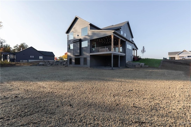 rear view of house featuring a yard and a balcony