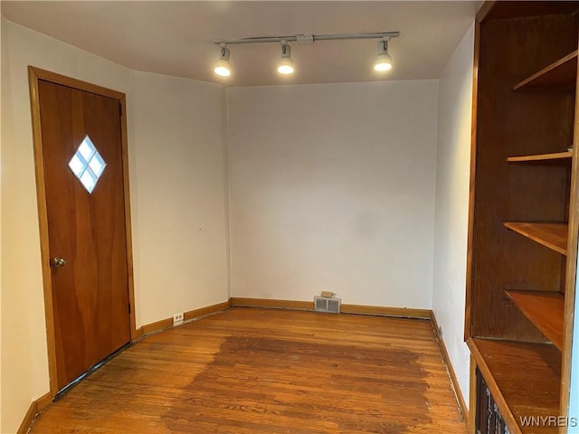 interior space featuring hardwood / wood-style flooring and rail lighting