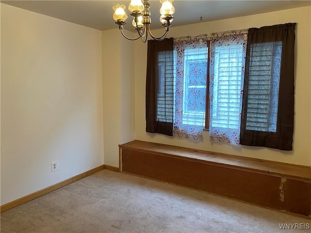 carpeted spare room with a chandelier