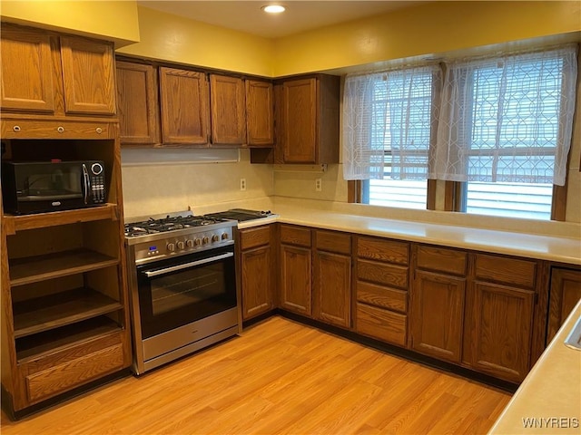 kitchen featuring high end stainless steel range oven and light wood-type flooring