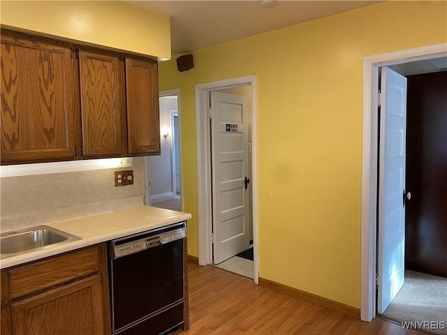 kitchen featuring sink, light hardwood / wood-style flooring, and black dishwasher