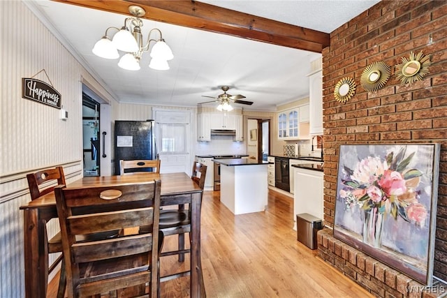 dining room with beamed ceiling, ceiling fan with notable chandelier, sink, and light hardwood / wood-style flooring