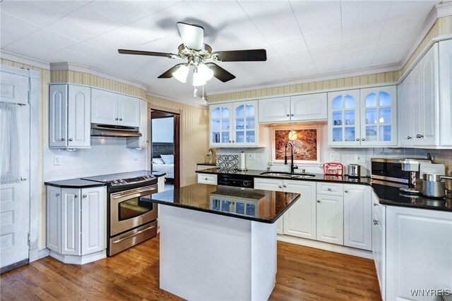 kitchen featuring sink, white cabinetry, a center island, stainless steel appliances, and hardwood / wood-style floors