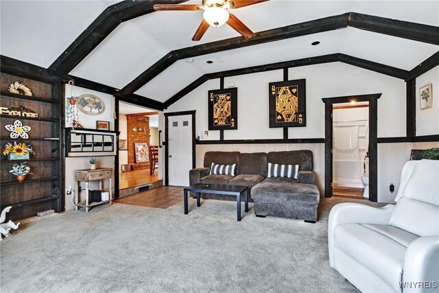 living room with ceiling fan, lofted ceiling with beams, and light carpet