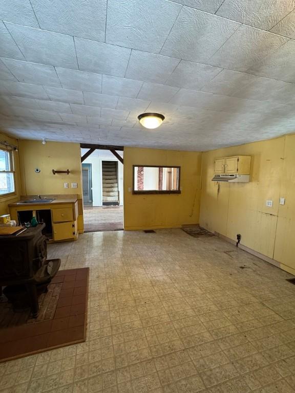 unfurnished living room with a wood stove