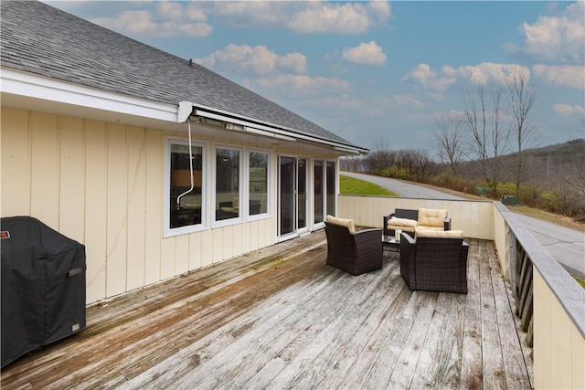 wooden terrace with outdoor lounge area and area for grilling