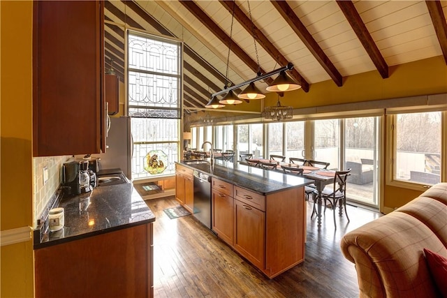 kitchen featuring stainless steel dishwasher, plenty of natural light, hanging light fixtures, and high vaulted ceiling