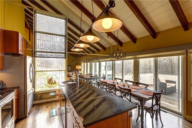 interior space with vaulted ceiling with beams, sink, a wealth of natural light, and an inviting chandelier