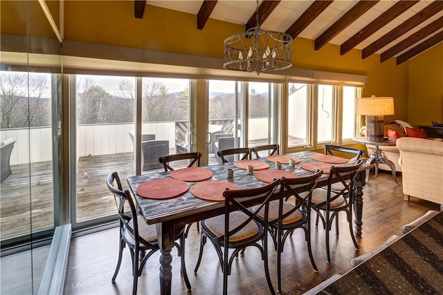 dining space featuring hardwood / wood-style floors, lofted ceiling with beams, plenty of natural light, and a notable chandelier