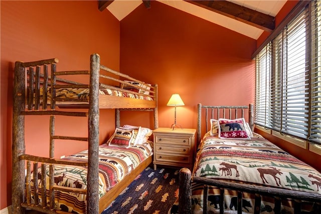 bedroom with beamed ceiling, high vaulted ceiling, and multiple windows