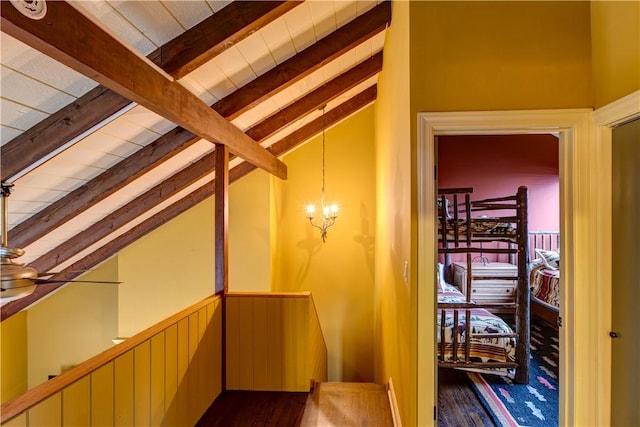 bonus room featuring lofted ceiling with beams, an inviting chandelier, and dark wood-type flooring