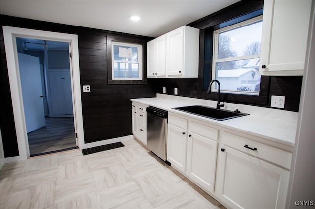 416 Broadway Ave E, Watertown-City, NY 13601 - kitchen with dishwasher, a sink, white cabinets, light countertops, and wood walls
