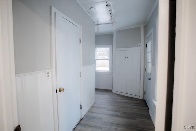 hallway featuring ornamental molding, rail lighting, and light hardwood / wood-style flooring