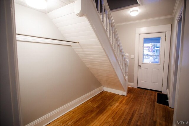 doorway to outside with dark hardwood / wood-style floors, lofted ceiling, and ornamental molding