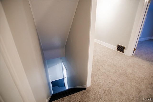 stairway with carpet and vaulted ceiling