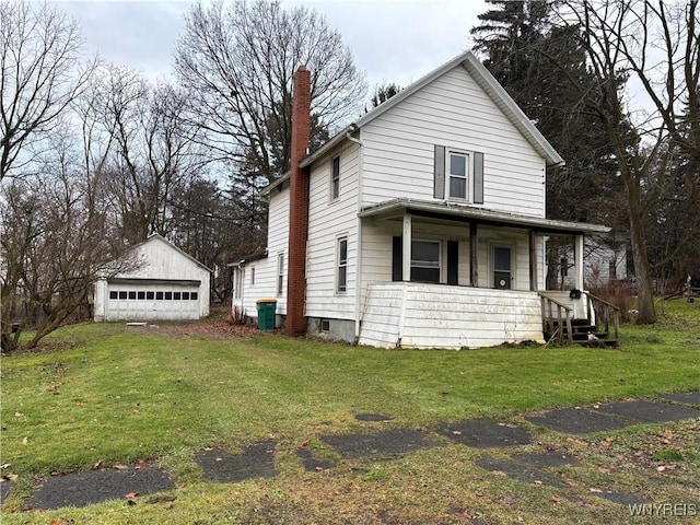 view of front of house featuring covered porch, a garage, an outdoor structure, and a front yard