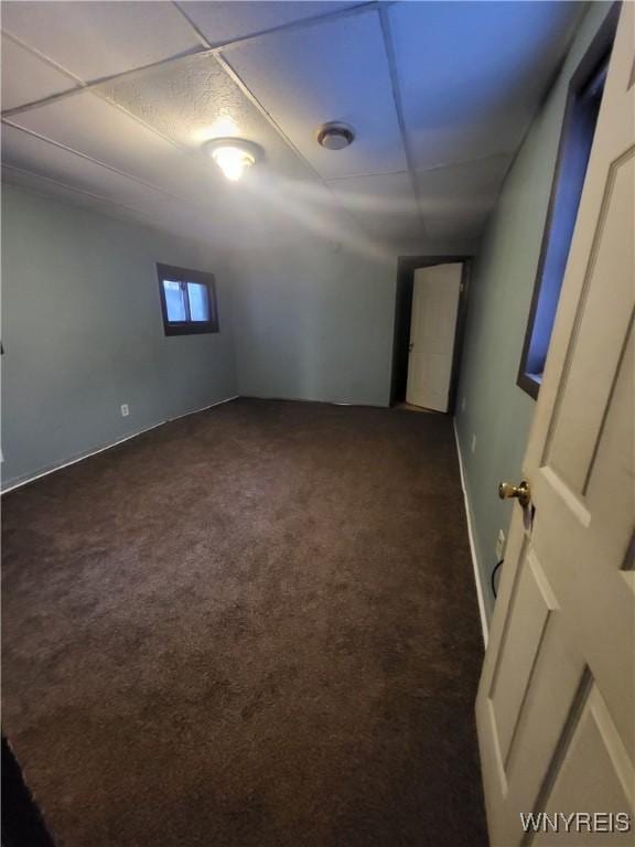 carpeted empty room featuring a paneled ceiling