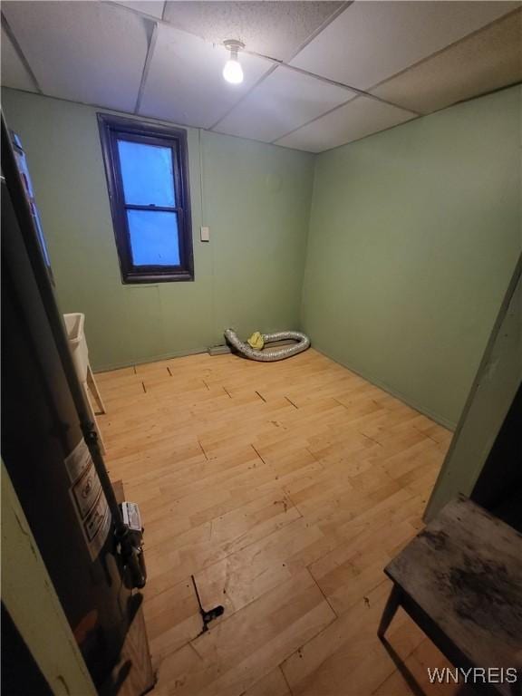 interior space featuring a paneled ceiling and hardwood / wood-style flooring