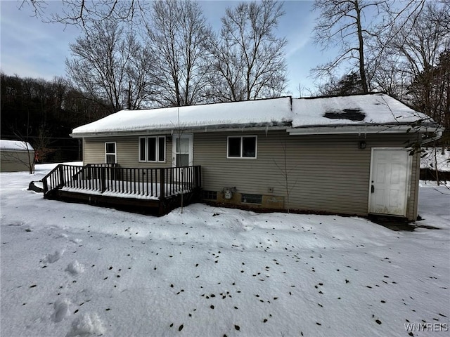 snow covered rear of property featuring a deck