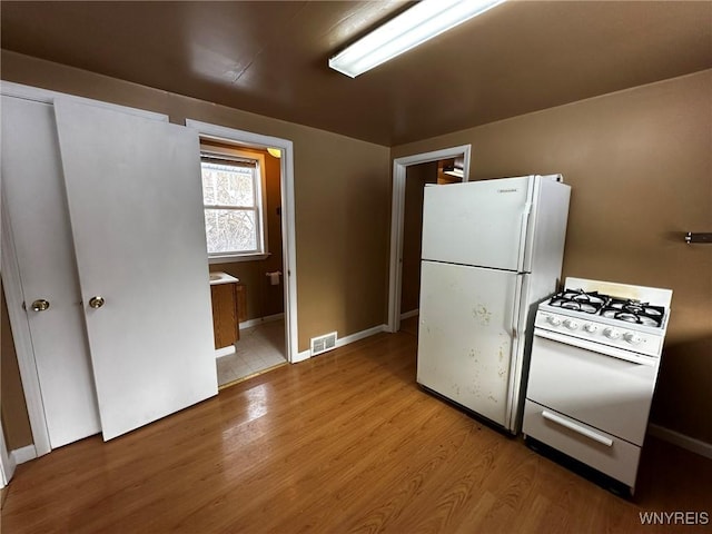 kitchen featuring white appliances and light hardwood / wood-style flooring