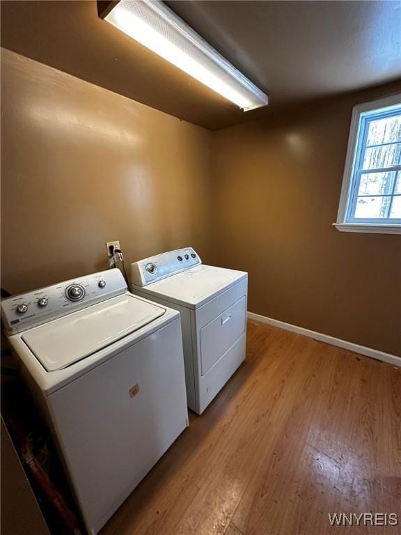 laundry area with light wood-type flooring and washing machine and clothes dryer