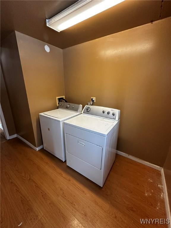 laundry area with light wood-type flooring and washing machine and dryer