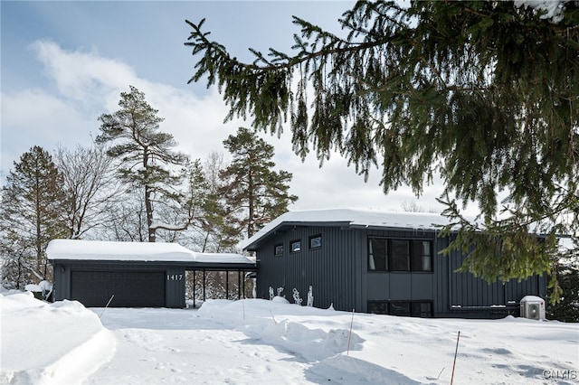 view of snowy exterior featuring a garage