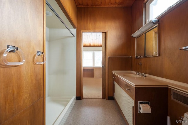 bathroom featuring vanity, walk in shower, wooden walls, and wood ceiling