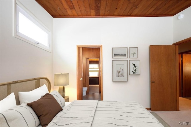 bedroom with ensuite bathroom, wooden ceiling, and multiple windows