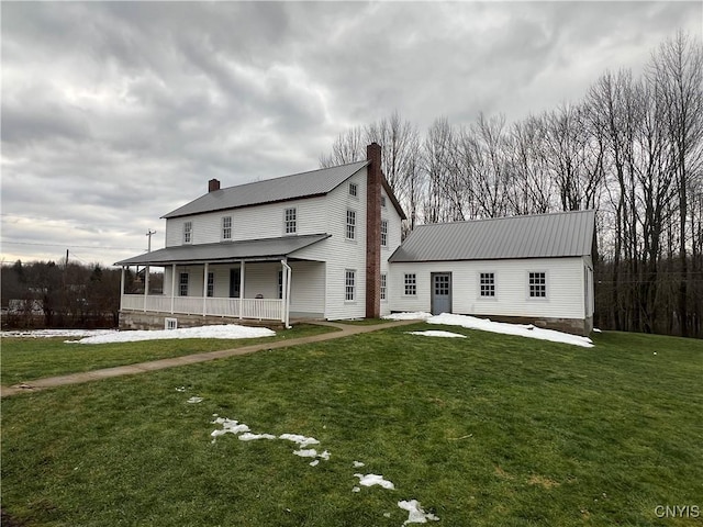 rear view of property with a porch and a lawn