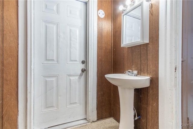 bathroom featuring wooden walls