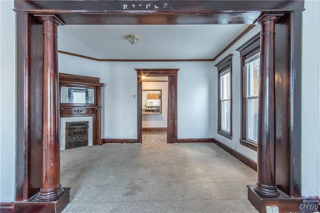 unfurnished living room with decorative columns, crown molding, and carpet