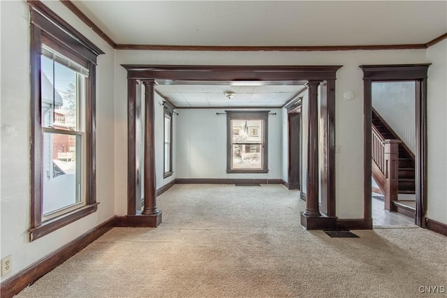 interior space featuring ornamental molding, light carpet, and decorative columns