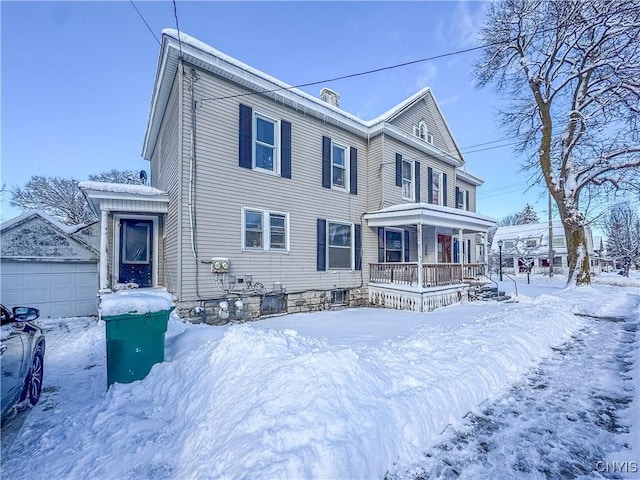 view of front of house with covered porch, an outbuilding, and a garage