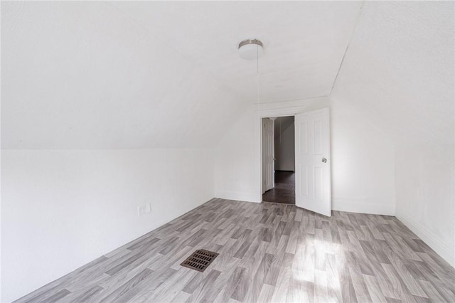 bonus room with light hardwood / wood-style flooring and vaulted ceiling