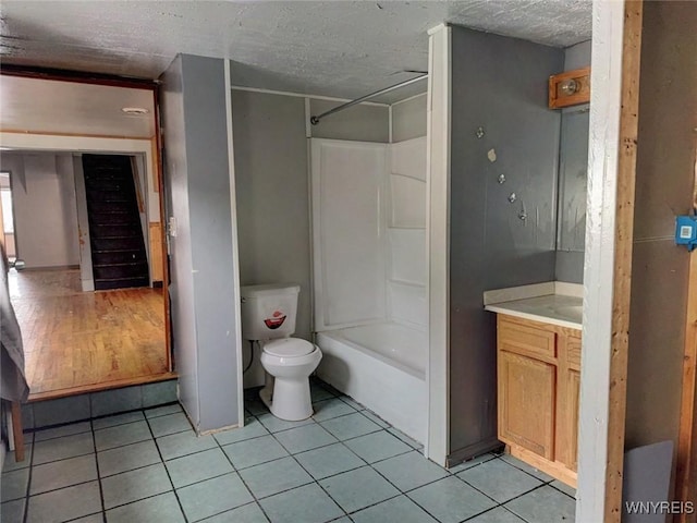 full bathroom with tile patterned floors, a textured ceiling, vanity, shower / bathing tub combination, and toilet