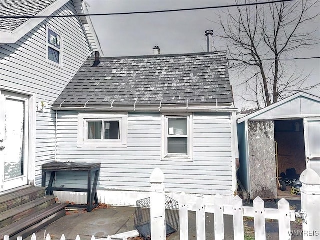 view of side of home with a patio area and a shed