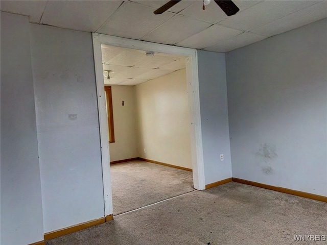 unfurnished room featuring carpet flooring, ceiling fan, and a drop ceiling