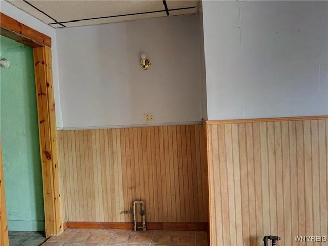 spare room with wood walls and light tile patterned floors