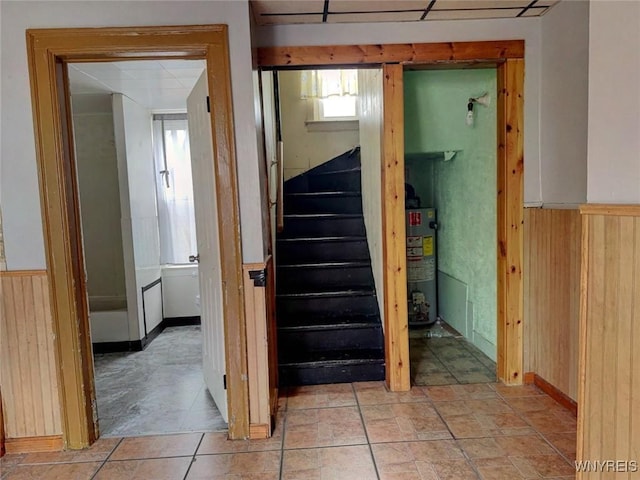 staircase with wood walls and water heater