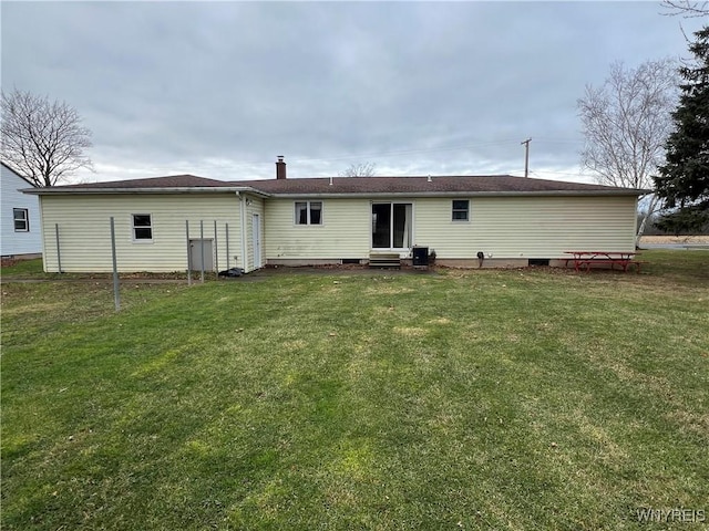 rear view of house featuring a lawn