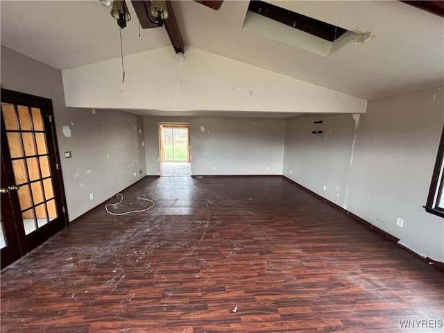 empty room with beam ceiling, high vaulted ceiling, and dark wood-type flooring