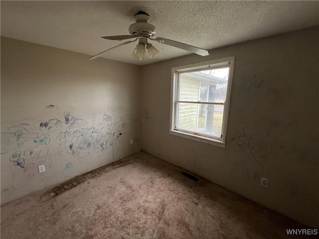 spare room with carpet, a textured ceiling, and ceiling fan