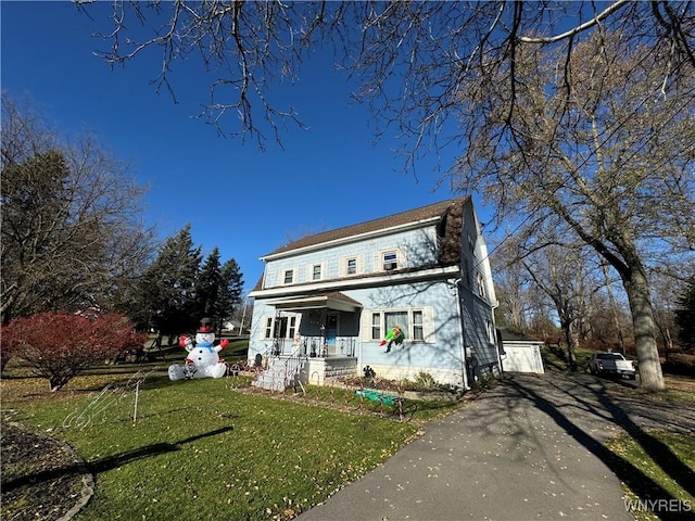 exterior space with a porch, a garage, an outdoor structure, and a front lawn